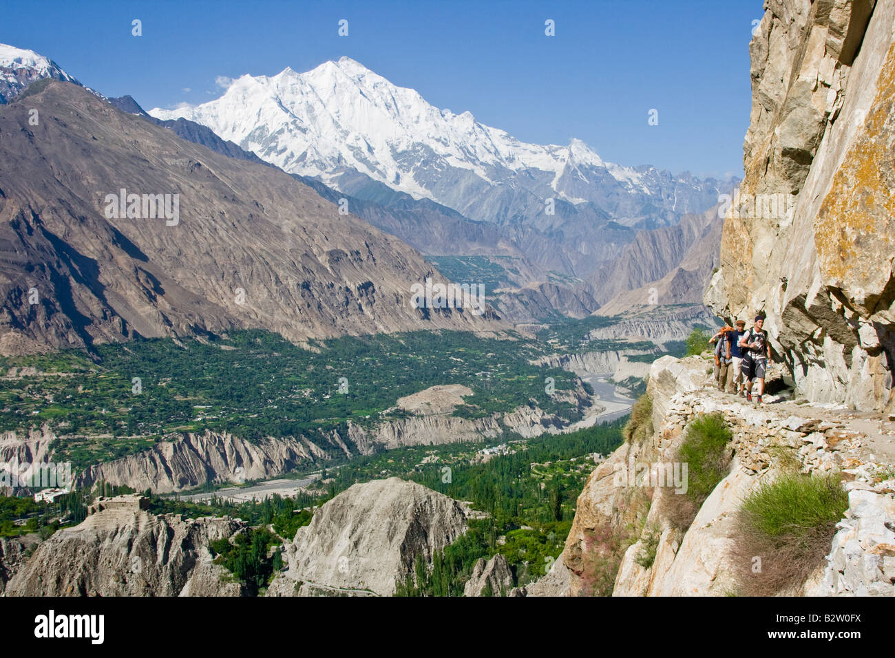 Les randonneurs sur un chemin précaire dans les montagnes au-dessus de la vallée de l'Hunza Karimabad dans le Nord du Pakistan Banque D'Images