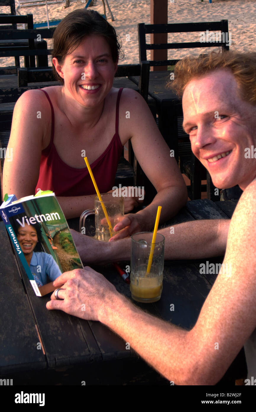 Jeune couple consulter Lonely Planet Guide du voyage Vietnam l'île de Phu Quoc Vietnam Banque D'Images