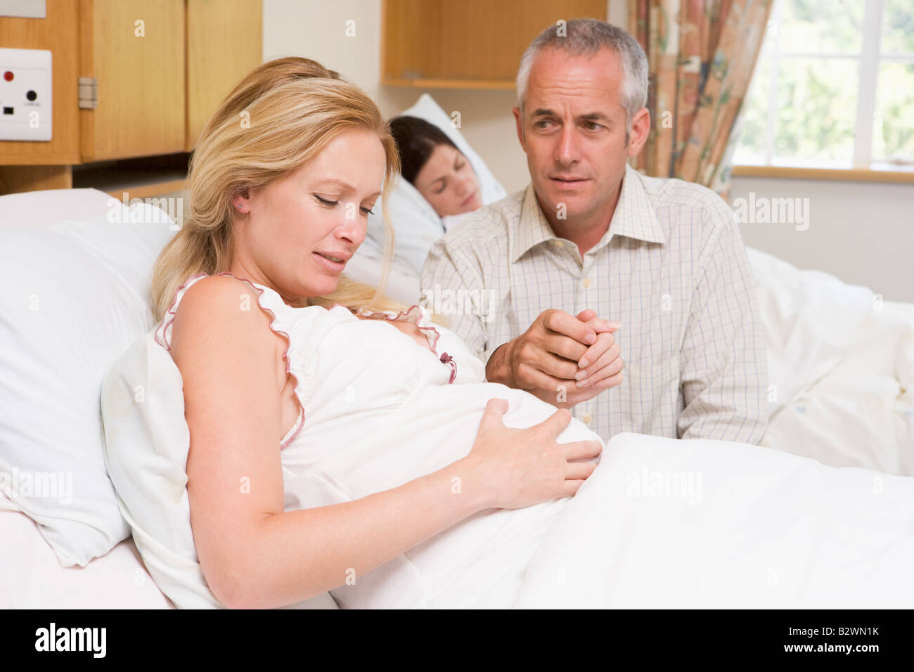 Femme enceinte dans la douleur avec son mari à l'hôpital Banque D'Images