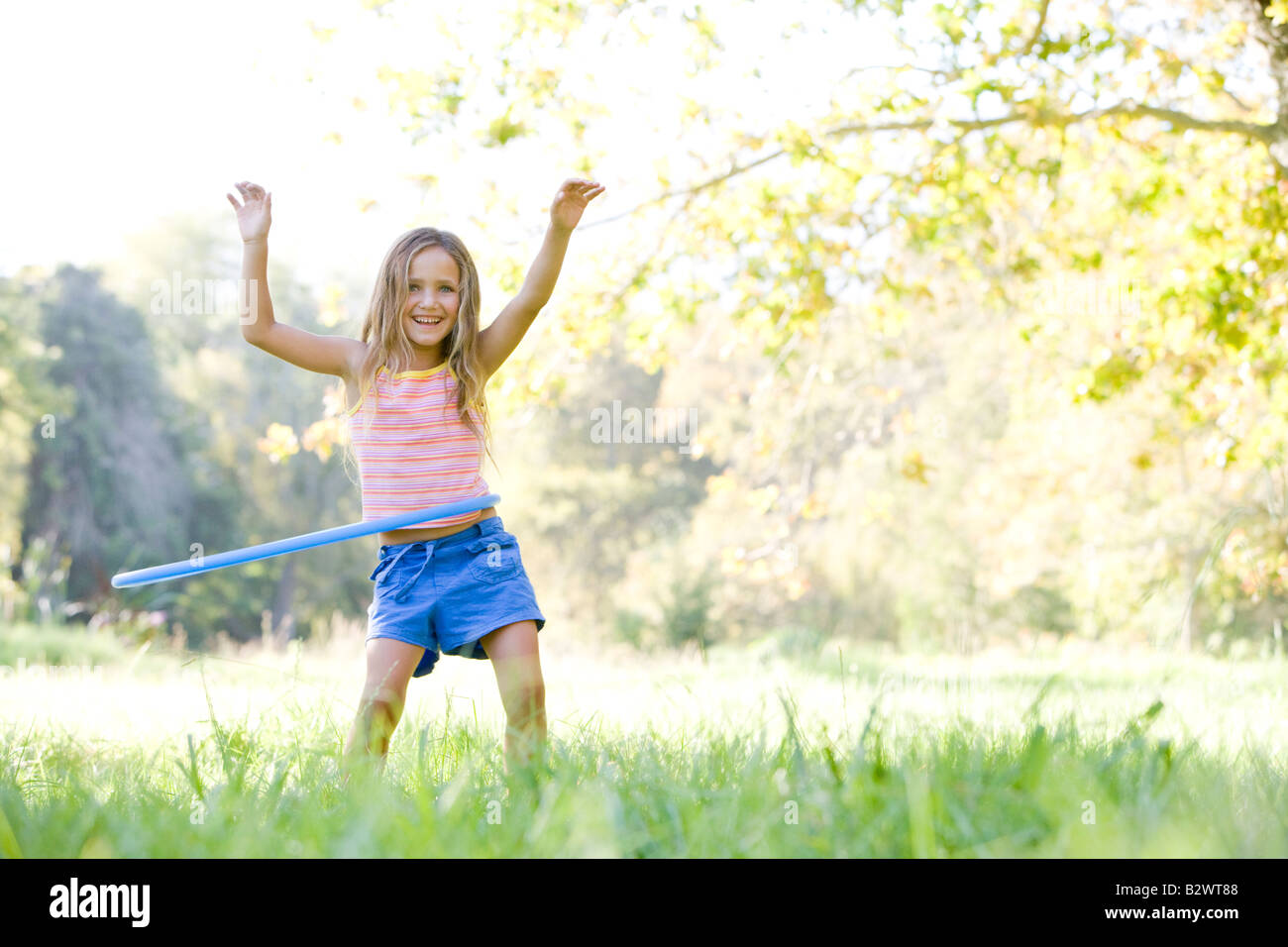 Jeune fille avec hula hoop outdoors smiling Banque D'Images