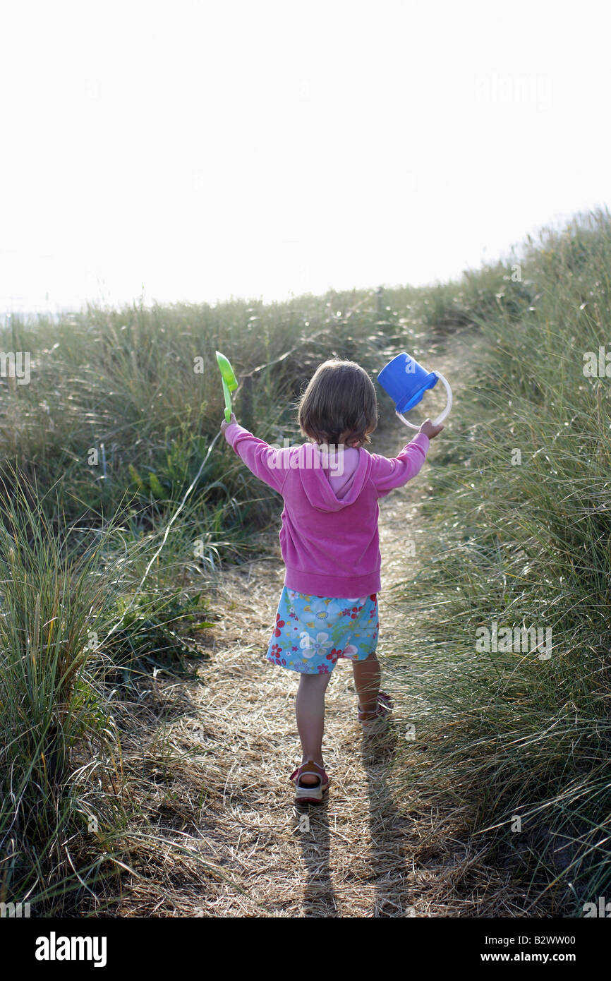 Fille avec toy seau et pelle sur une dune Banque D'Images