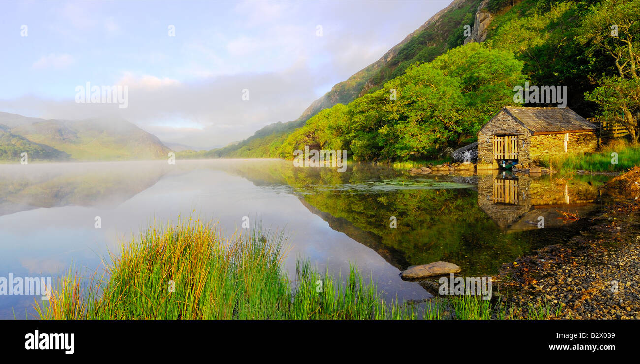 Un petit hangar à bateaux sur un beau matin brumeux et calme à Llyn Dinas dans le parc national de Snowdonia au nord du Pays de Galles Banque D'Images