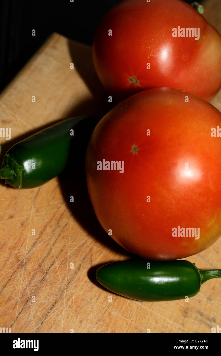 Deux tomates et piments jalapeño deux sur le bois. Banque D'Images