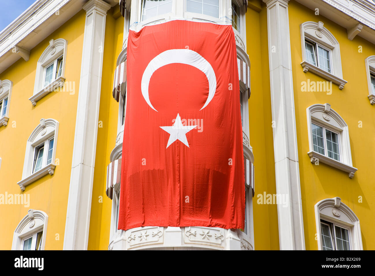 Drapeau turc accroché à l'extérieur d'un bâtiment jaune à Sultanahmet, Istanbul, Turquie Banque D'Images