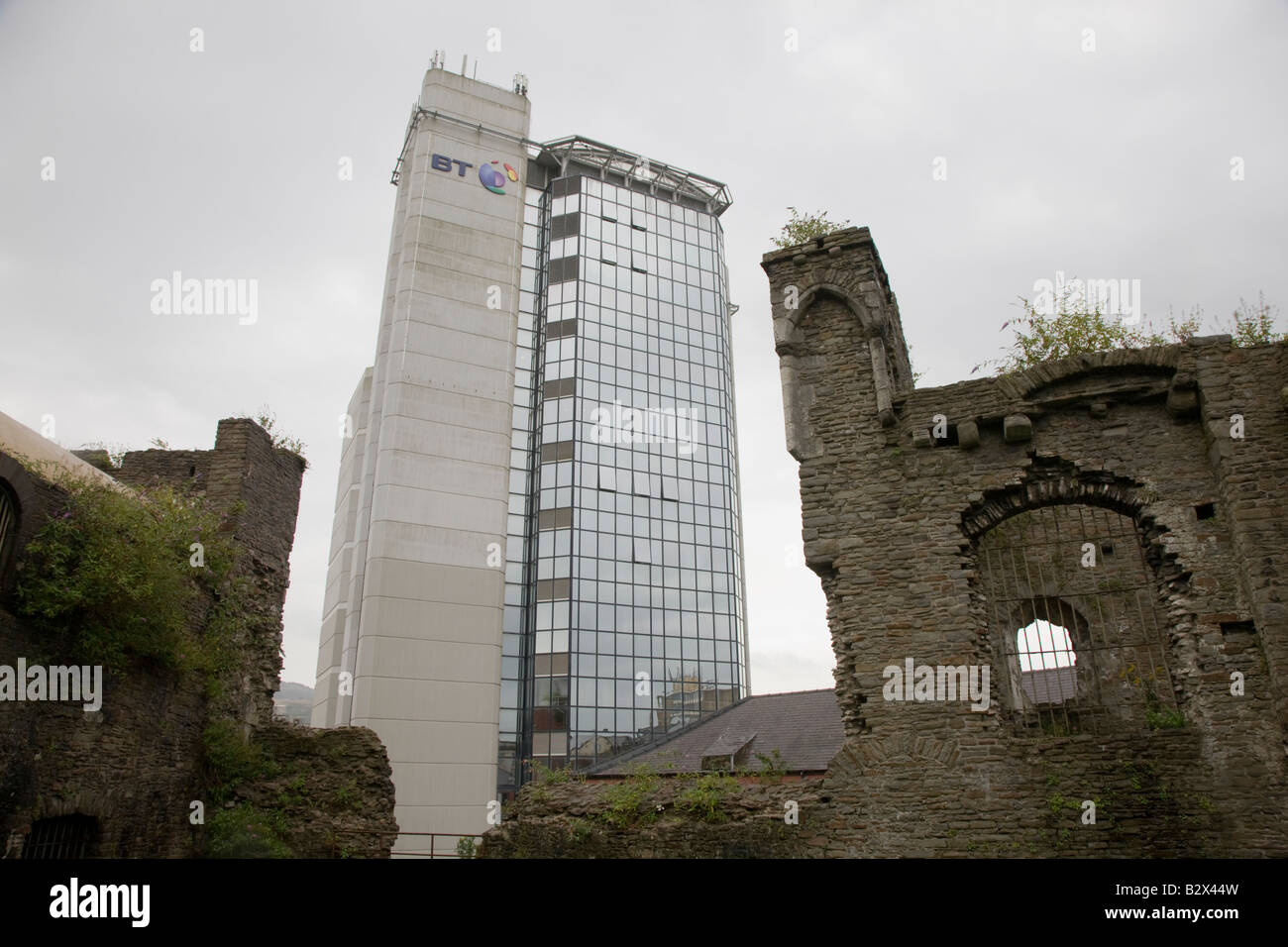 Un immeuble de bureaux moderne BT domine les ruines de l'ancien château de Swansea Banque D'Images