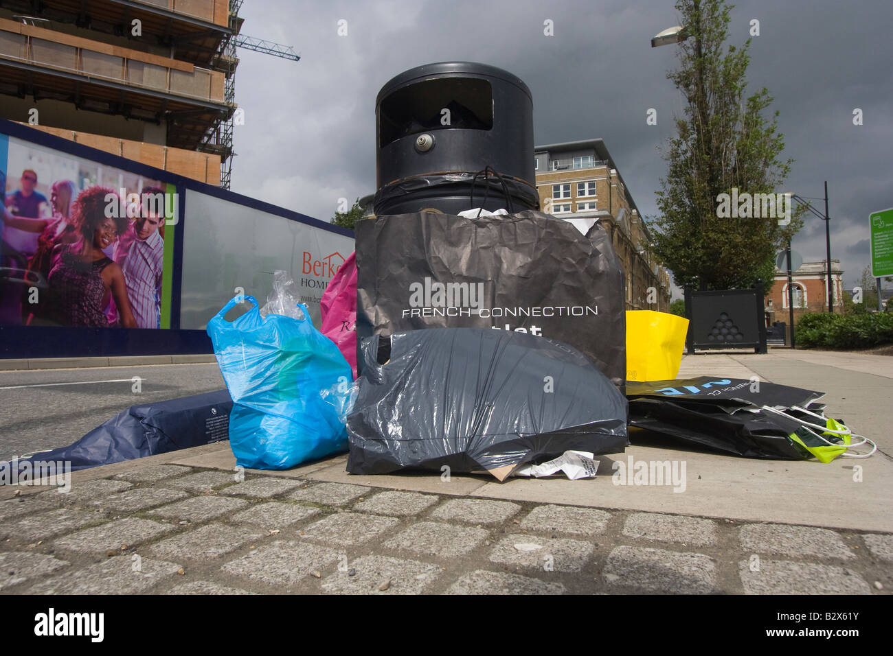 Poubelles débordant avec sacs designer et emballage Banque D'Images