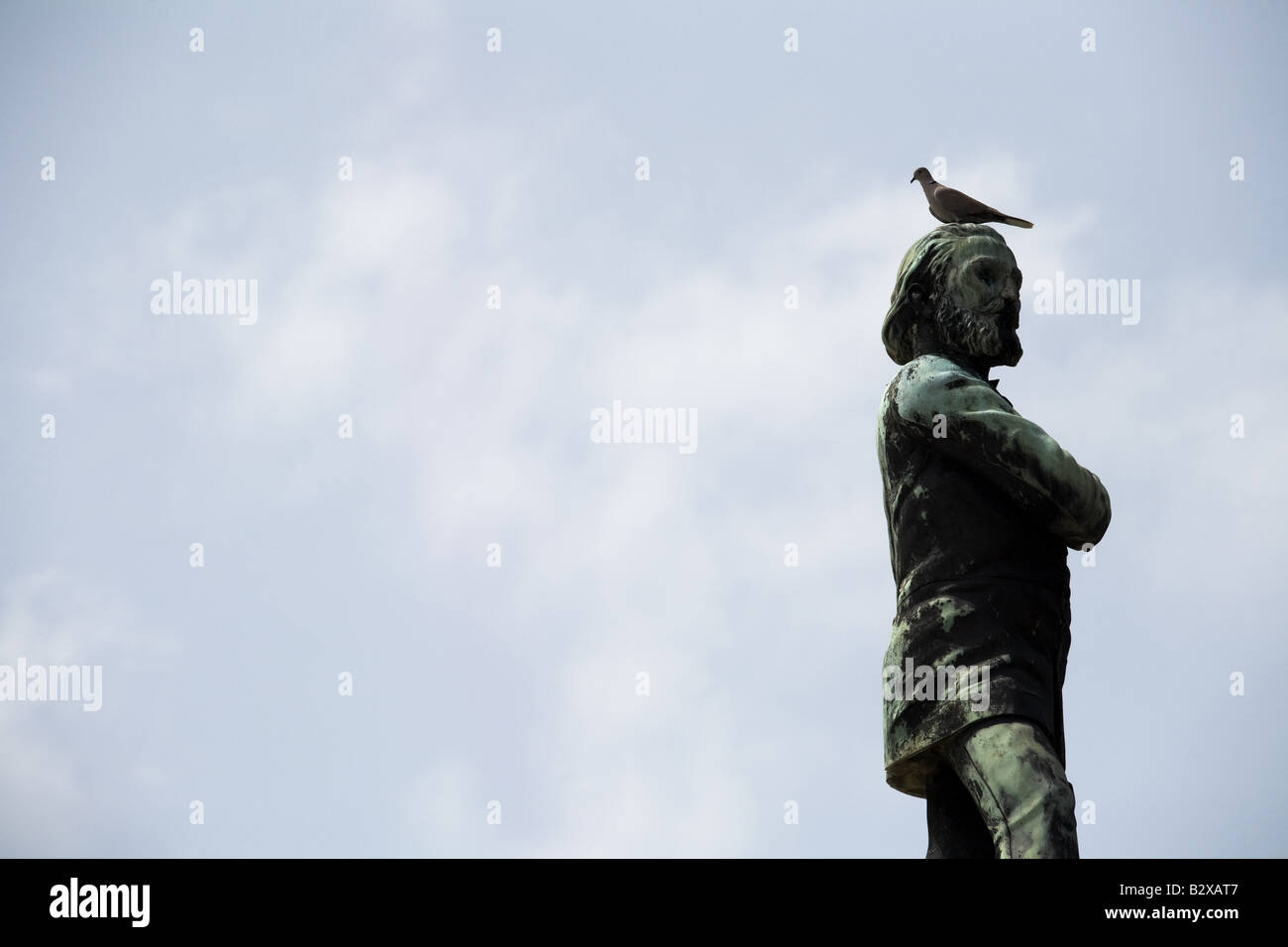 Un oiseau repose sur la tête d'une statue à la Nécropole Cristobal Colon cimetière à La Havane, Cuba Banque D'Images