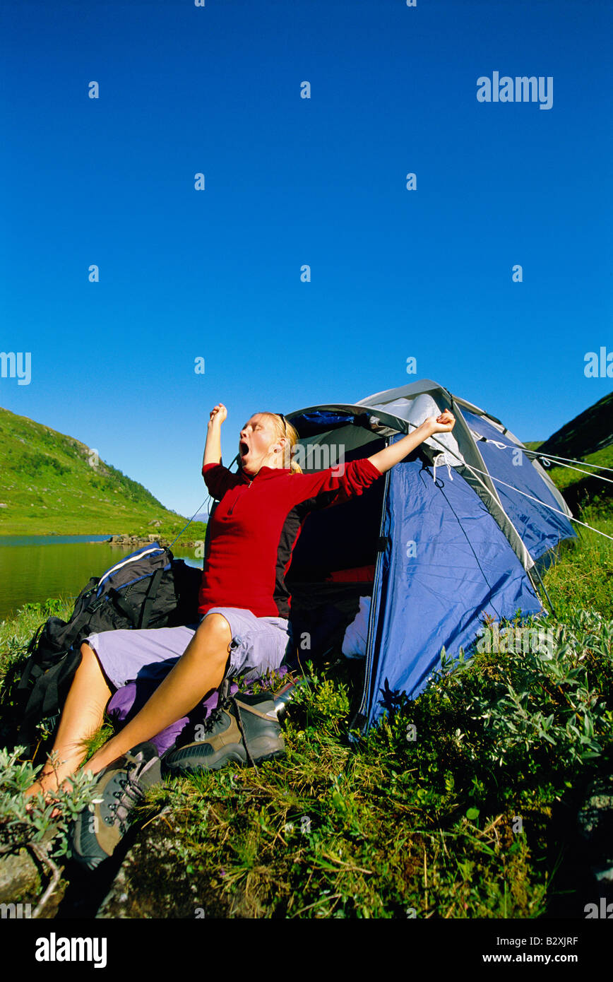 Femme en plein air au camping du lac par le bâillement et l'étirement Banque D'Images