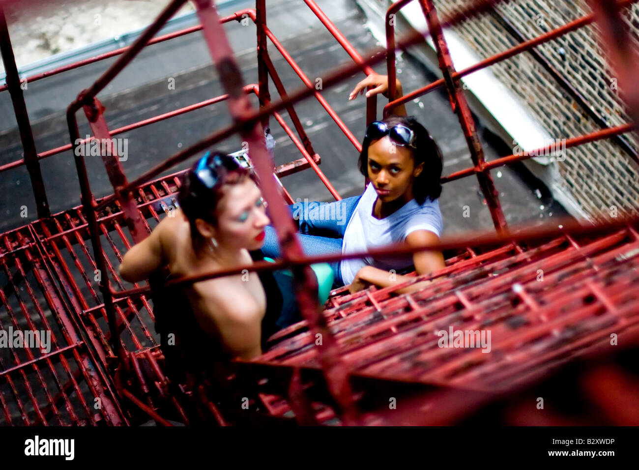 Deux jeunes filles traîner sur une issue de secours dans la ville. Banque D'Images