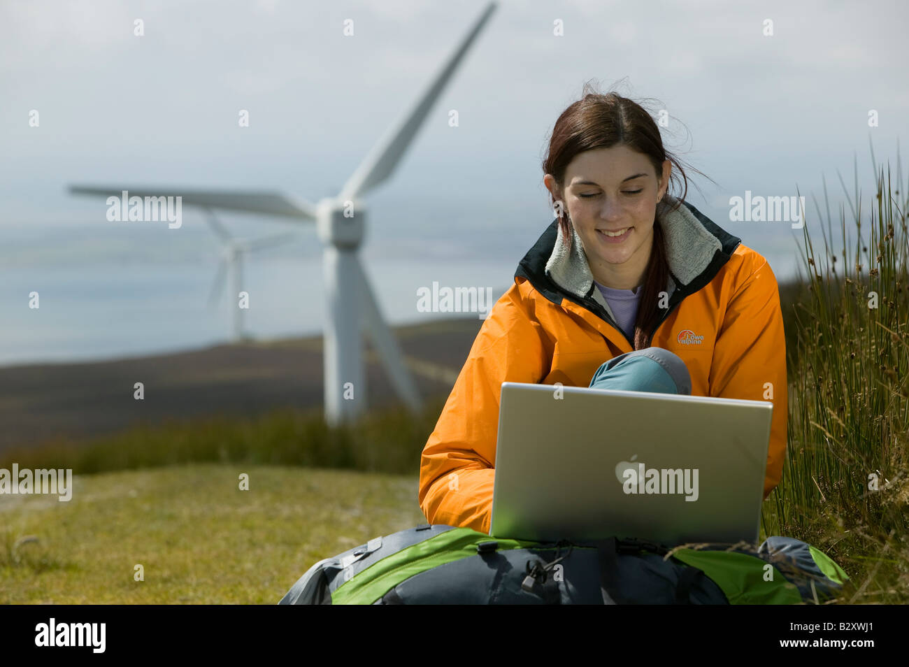 Femme avec un ordinateur portable et d'éoliennes en arrière-plan Banque D'Images