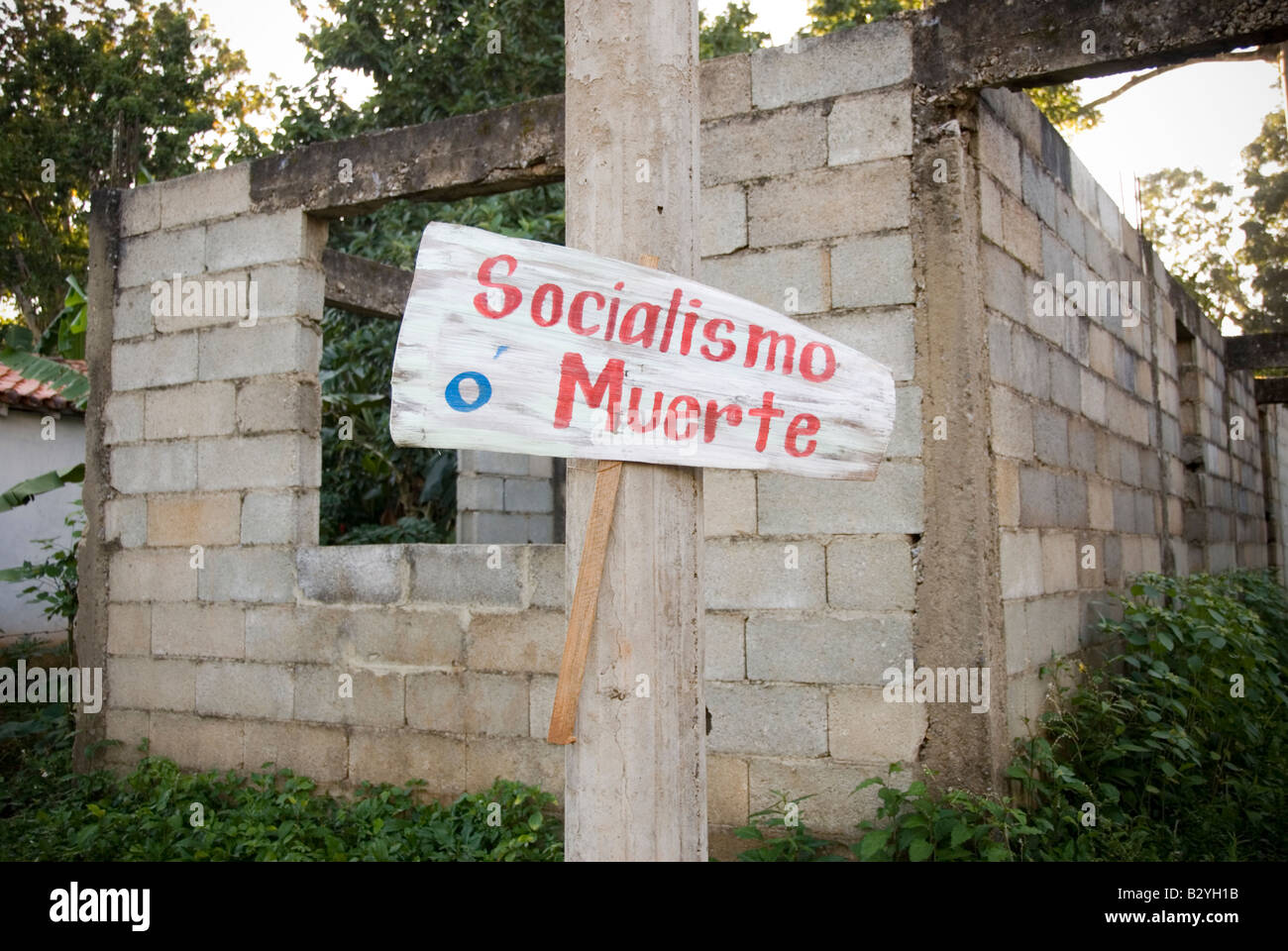 La mort ou le socialisme sign in front of unfinished building construction avec mauvaises herbes Cuba Banque D'Images