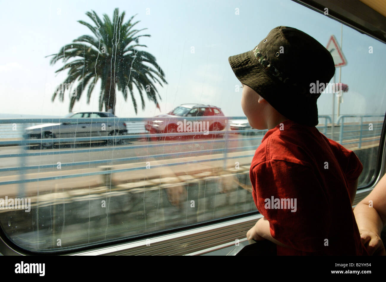 Un jeune garçon à la recherche d'une fenêtre de train Banque D'Images