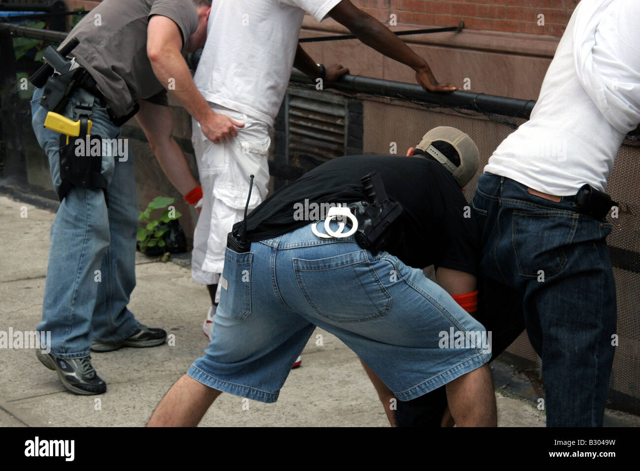Des détectives en civil contre la criminalité fouillant des suspects à Harlem New York Banque D'Images