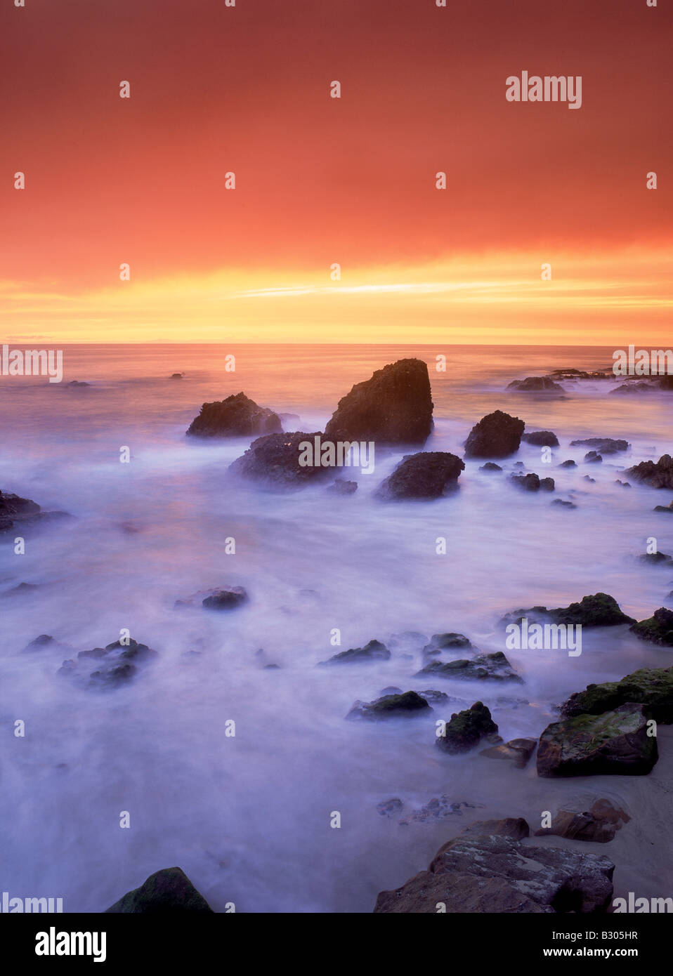 Peinture des rochers et vagues de sable au coucher du soleil à Woods Cove à Laguna Beach, Californie Banque D'Images