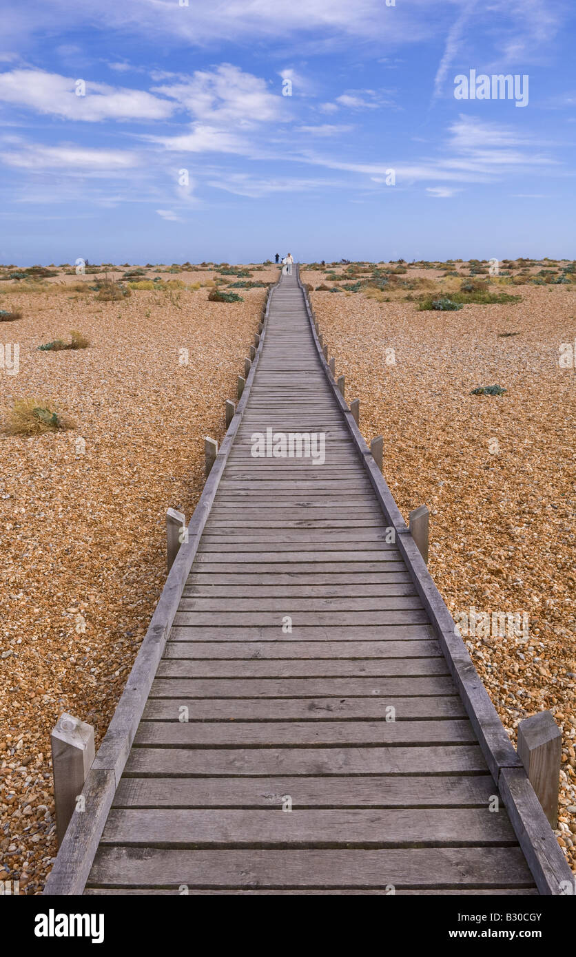 Promenade en bois s'étend dans la distance de l'autre côté de la plage de galets à Dungeness, dans le Kent, un jour ensoleillé Banque D'Images