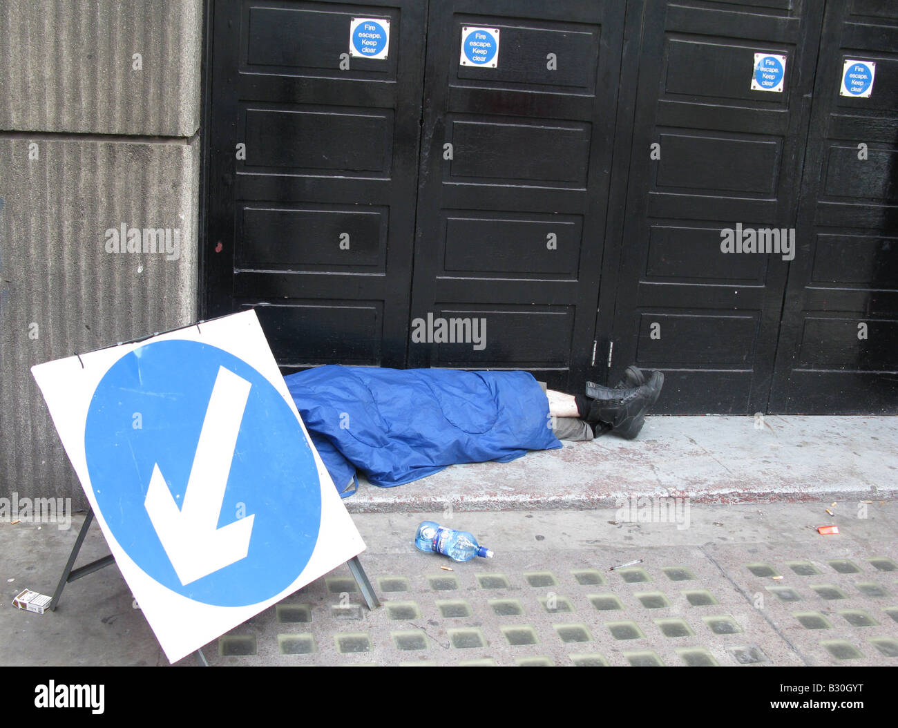 Down and Out ? Road to ruin ? Un sans-abri dort dans une porte à Victoria, Londres. Banque D'Images