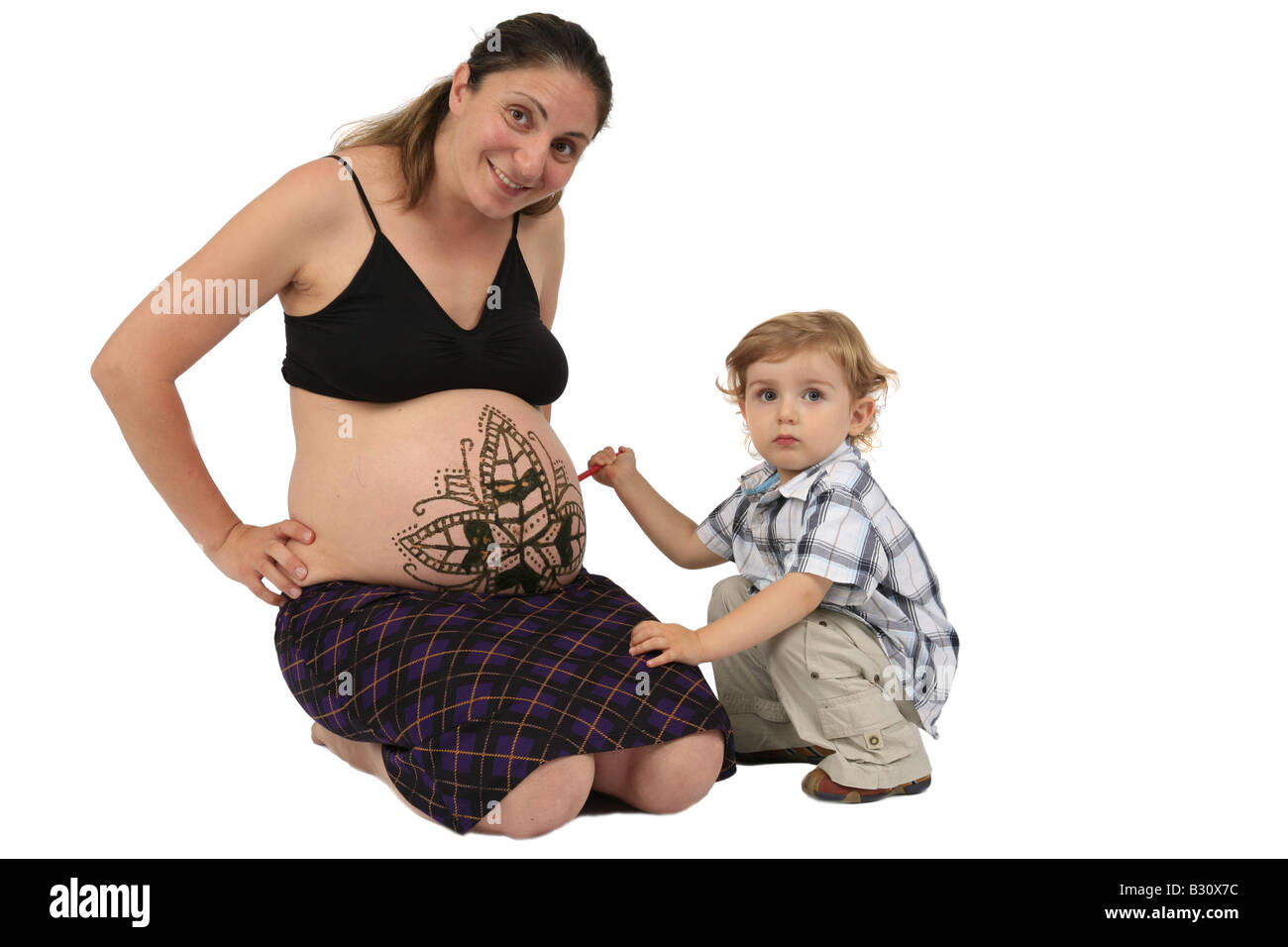Petit garçon regardant henna tatouage sur le ventre d'une femme enceinte Banque D'Images Petit garçon regardant henna tatouage sur le ventre d'une femme enceinte Banque D'Images