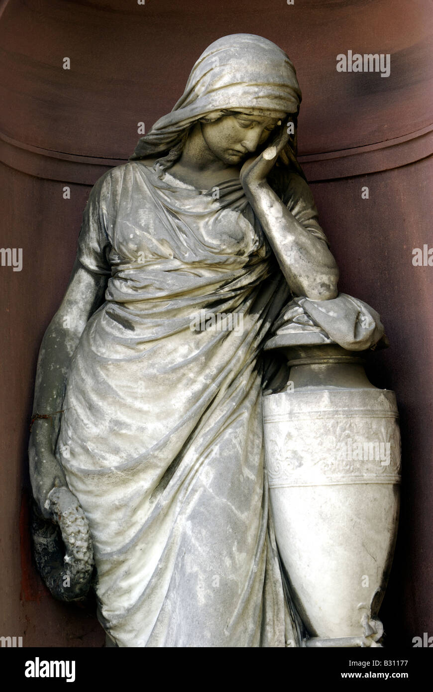 Statue d'une femme qui pleure avec une couronne dans une tombe, niche avec une urne Banque D'Images