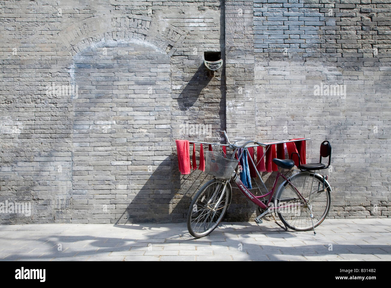 Scène de rue d'un vélo et le lavage dans un Hutong de Beijing traditionnelle, Banque D'Images