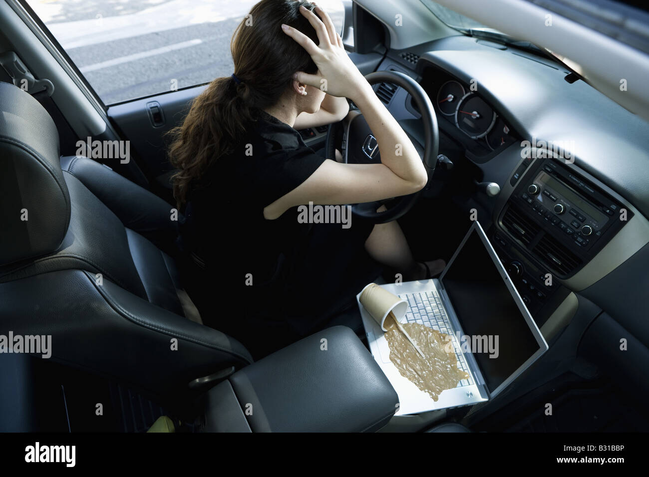 Jeune femme contrariée par tasse de café renversé Banque D'Images Jeune femme contrariée par tasse de café renversé Banque D'Images