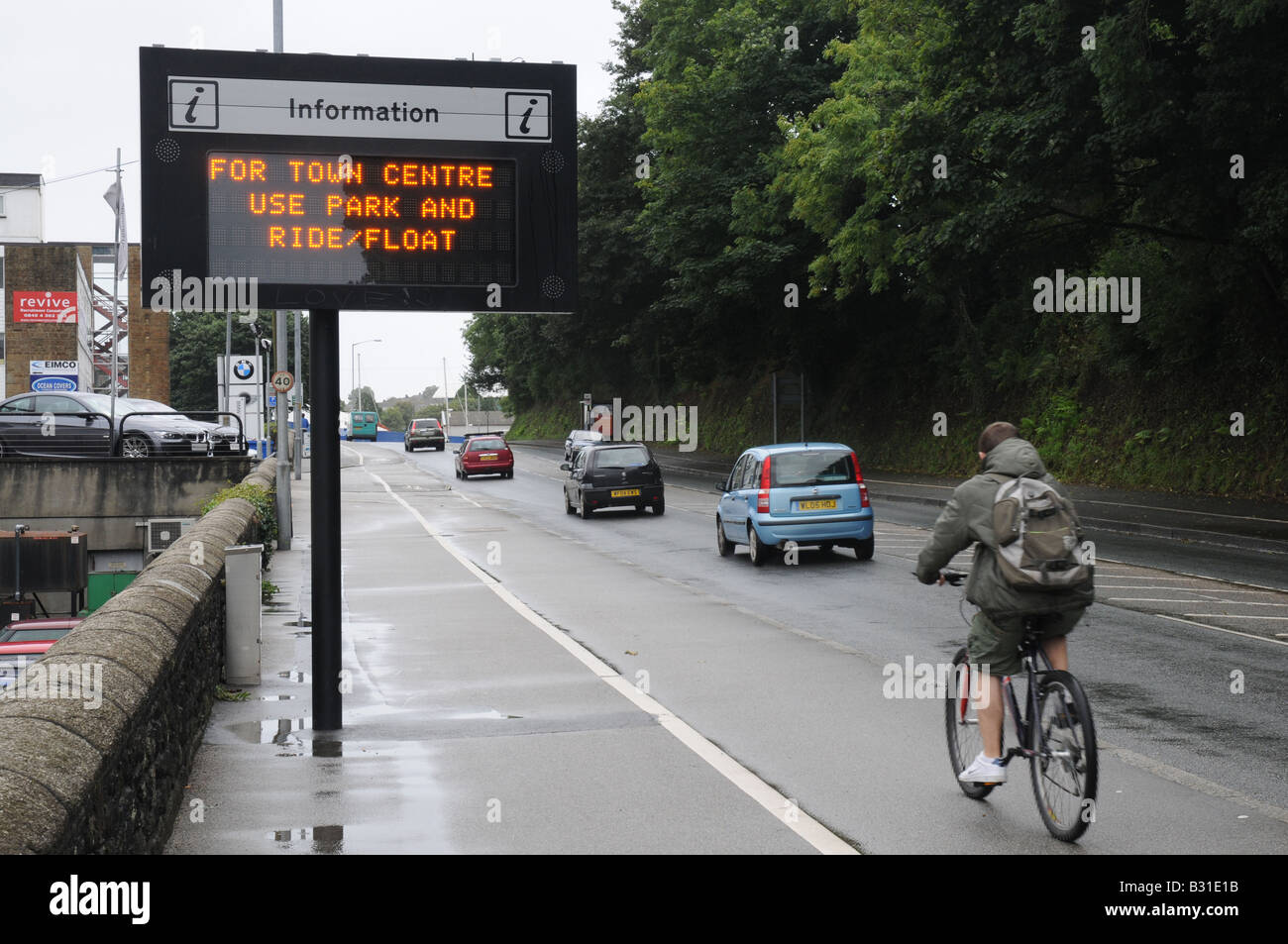 Un cycliste passe de stationnement électronique informations inscription sur place dans Falmouth, Royaume-Uni Banque D'Images