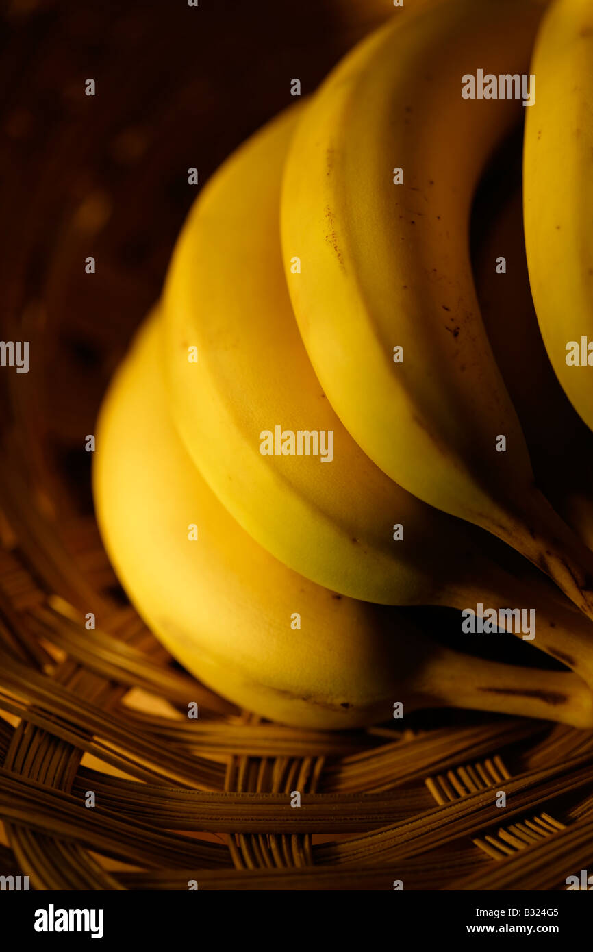 Main de bananes dans panier en osier Banque D'Images