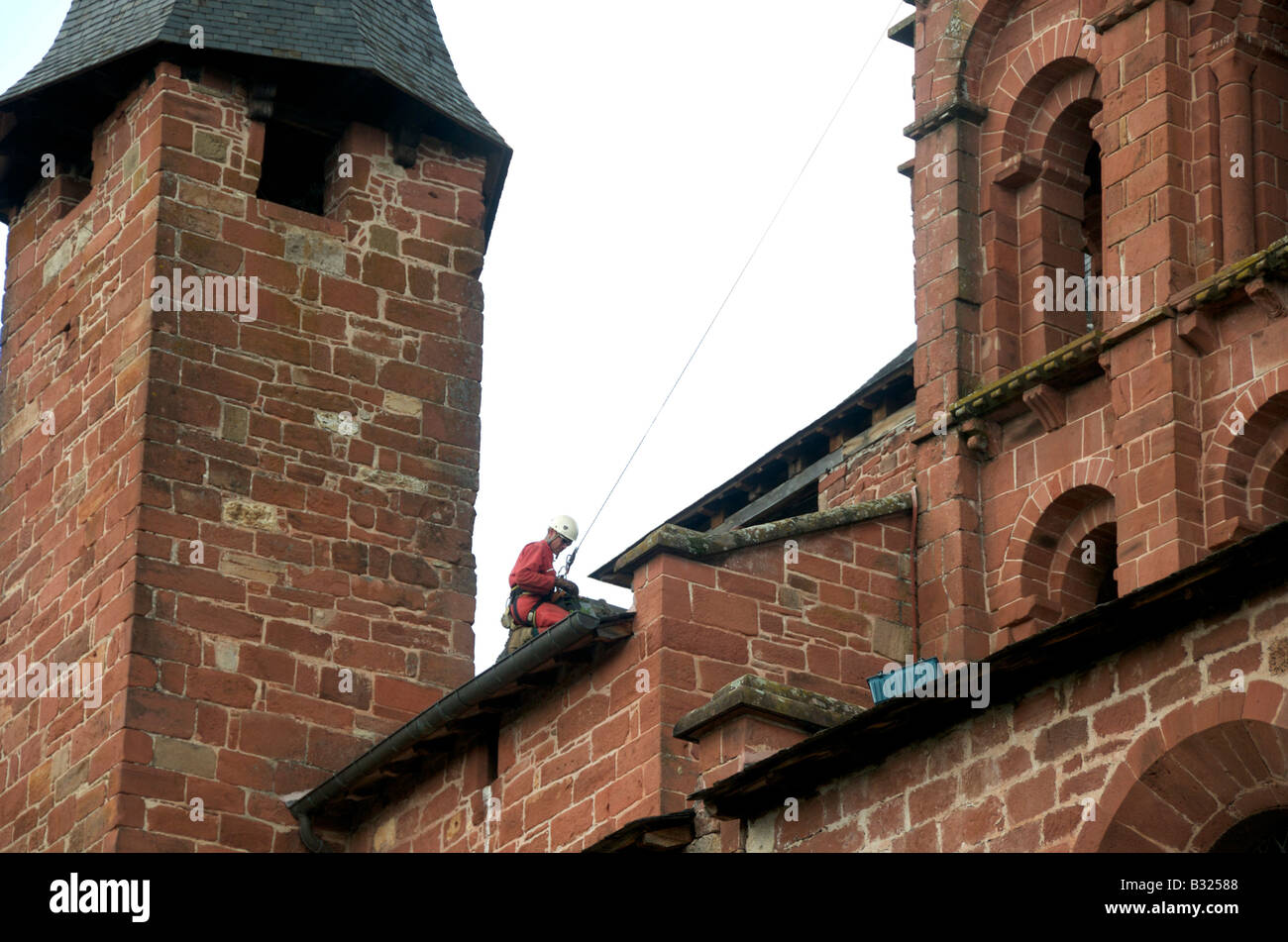 L'homme travaillant sur un toit pour nettoyer l'église Banque D'Images