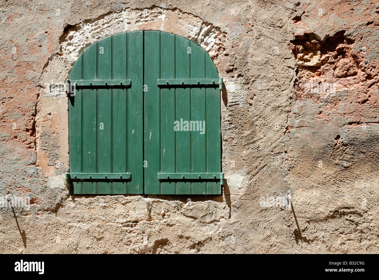 Mur avec fenêtre verte en Roussillon France Banque D'Images