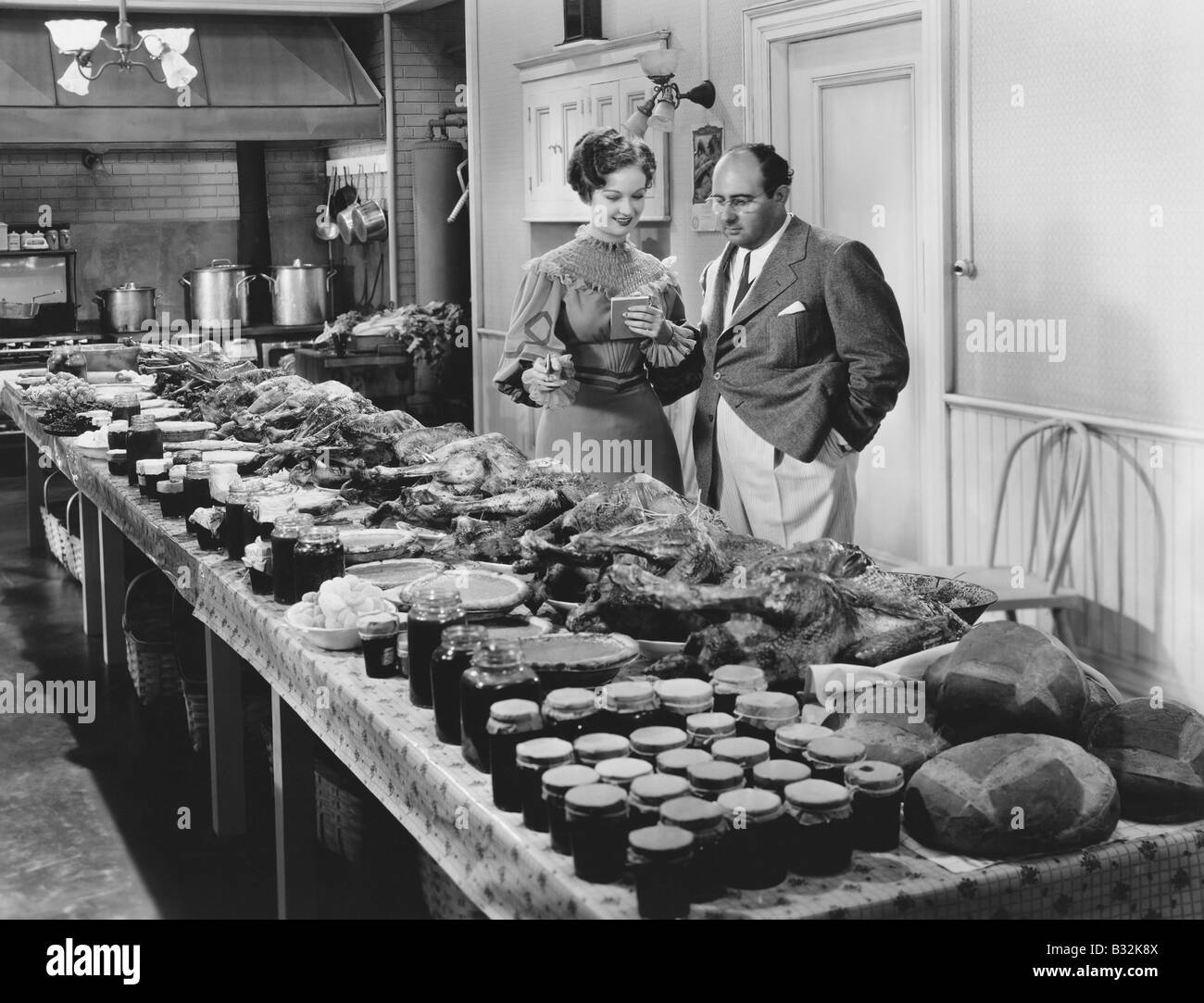 Couple avec une table couverte de nourriture pour repas de vacances Banque D'Images