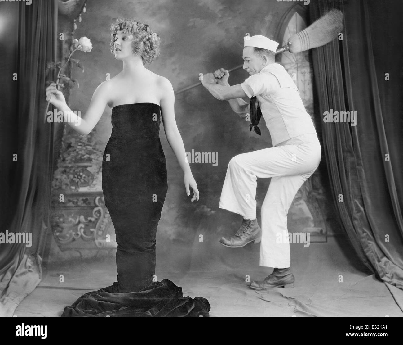 Femme élégante frapper Sailor avec broom Banque D'Images