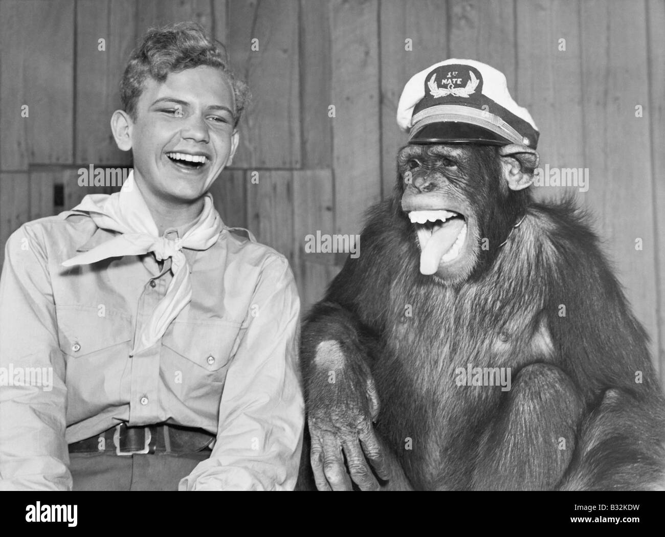 Laughing boy-scout et monkey wearing hat Banque D'Images