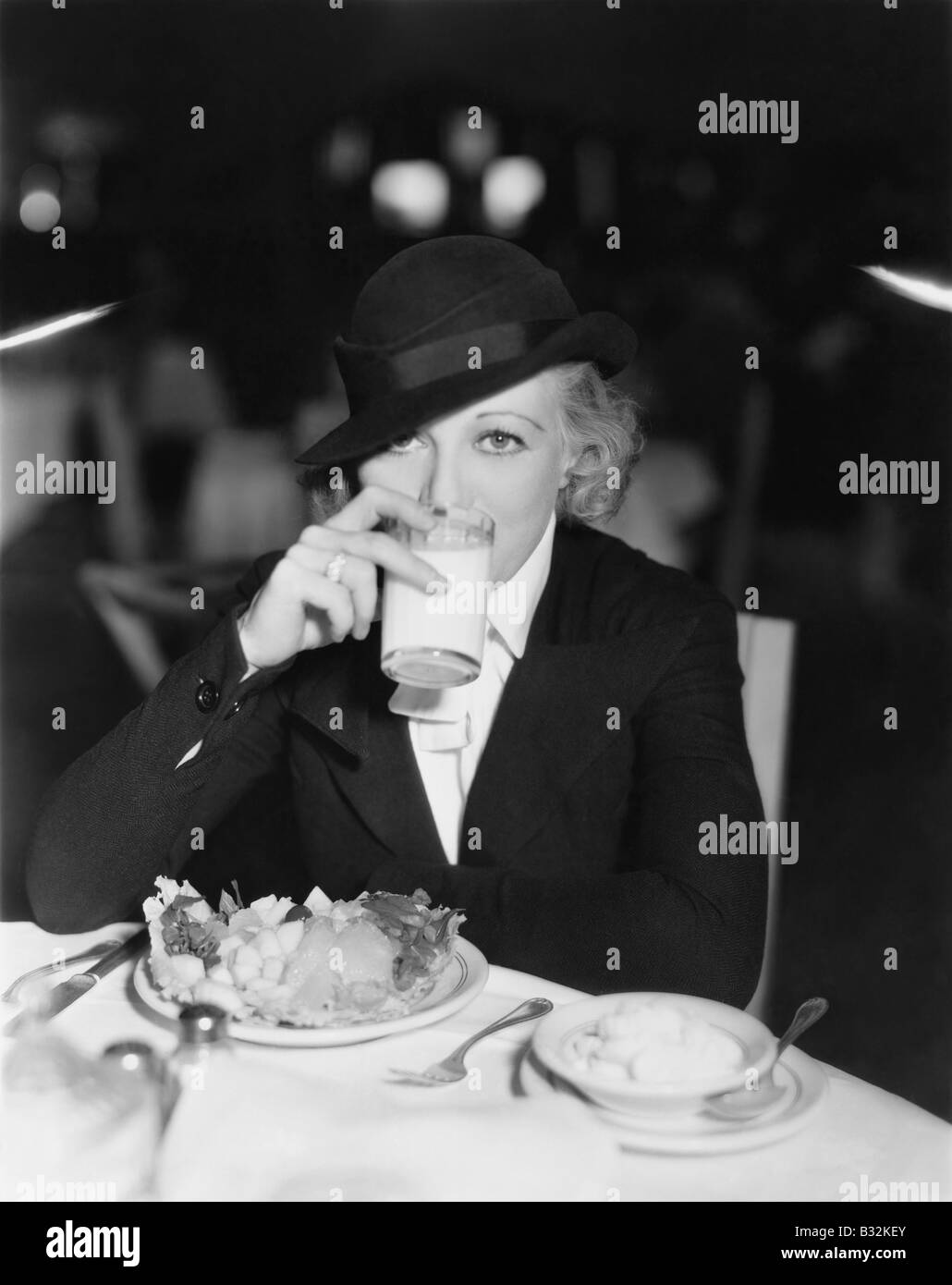 Portrait de femme à boire et manger au restaurant Banque D'Images