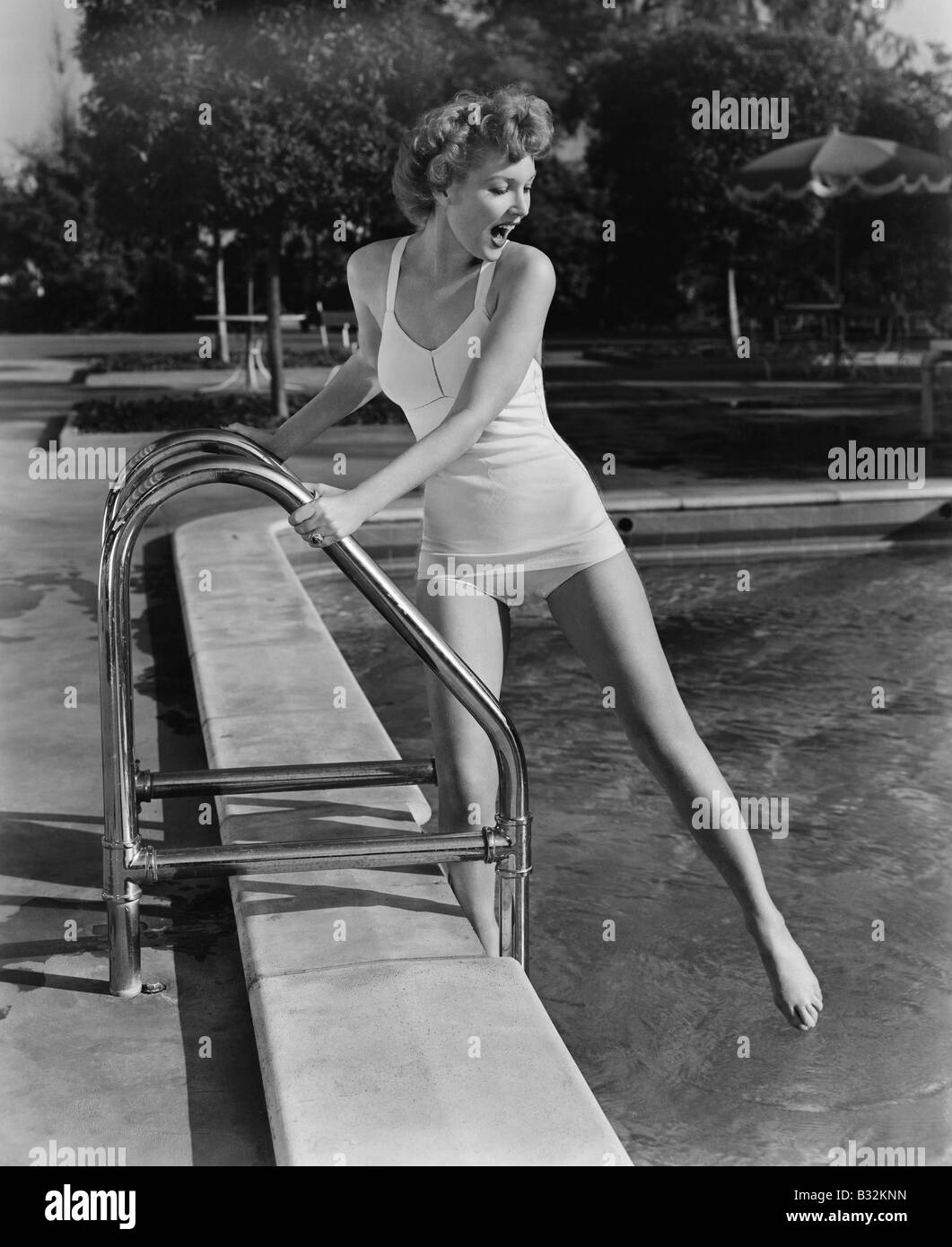 Femme trempant les orteils dans une piscine extérieure Banque D'Images