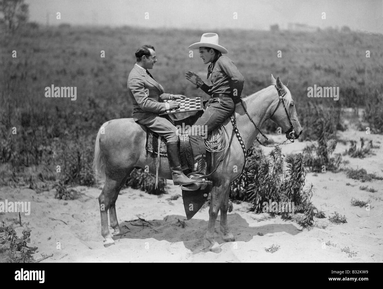 Cowboy et businessman jouer aux dames à cheval Banque D'Images