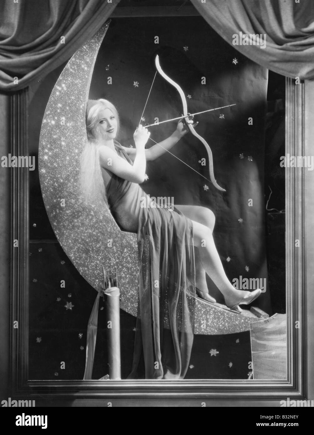Femme assise sur Croissant de lune avec arc et flèche Banque D'Images