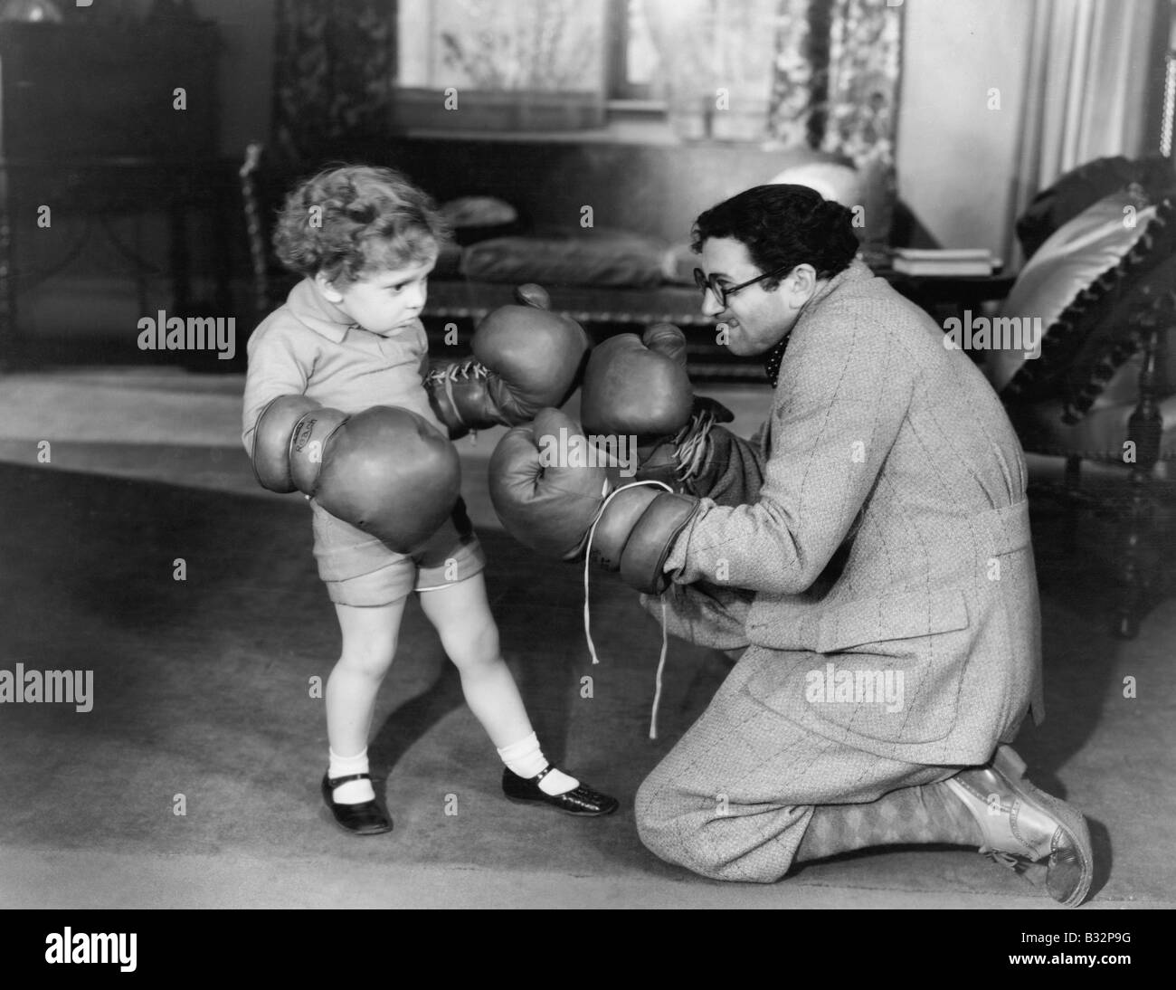 Le père et le jeune fils de jouer avec des gants de boxe Banque D'Images