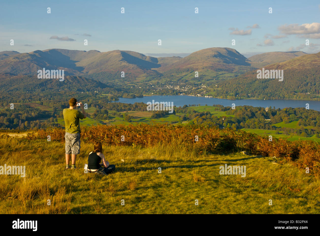 Homme et femme sur Latterbarrow, profitant de la vue sur le lac Windermere et Ambleside, Parc National de Lake District, Cumbria, Royaume-Uni Banque D'Images