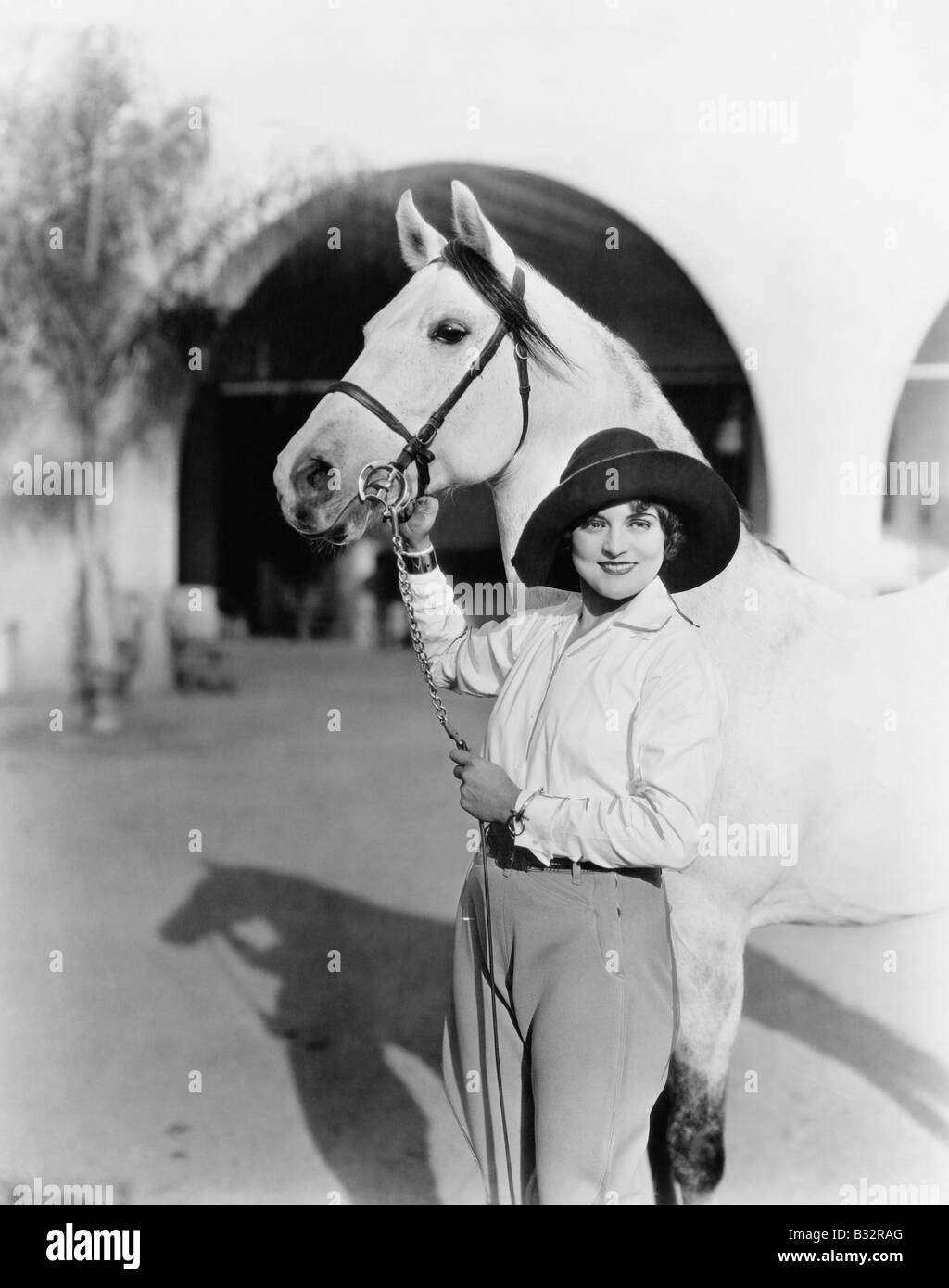 Jeune femme debout fièrement avec son cheval Banque D'Images