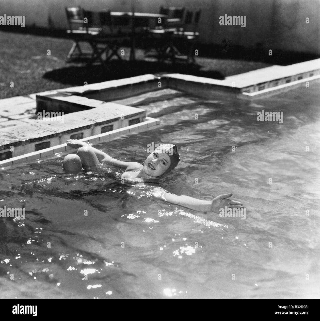 Femme de nager dans une piscine avec un bonnet de bain Banque D'Images