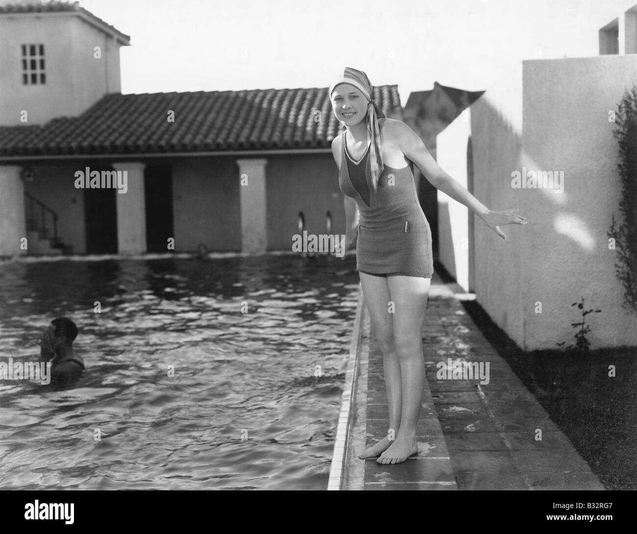 Femme à côté d'une piscine dans son bonnet de bain et maillot de bain Banque D'Images
