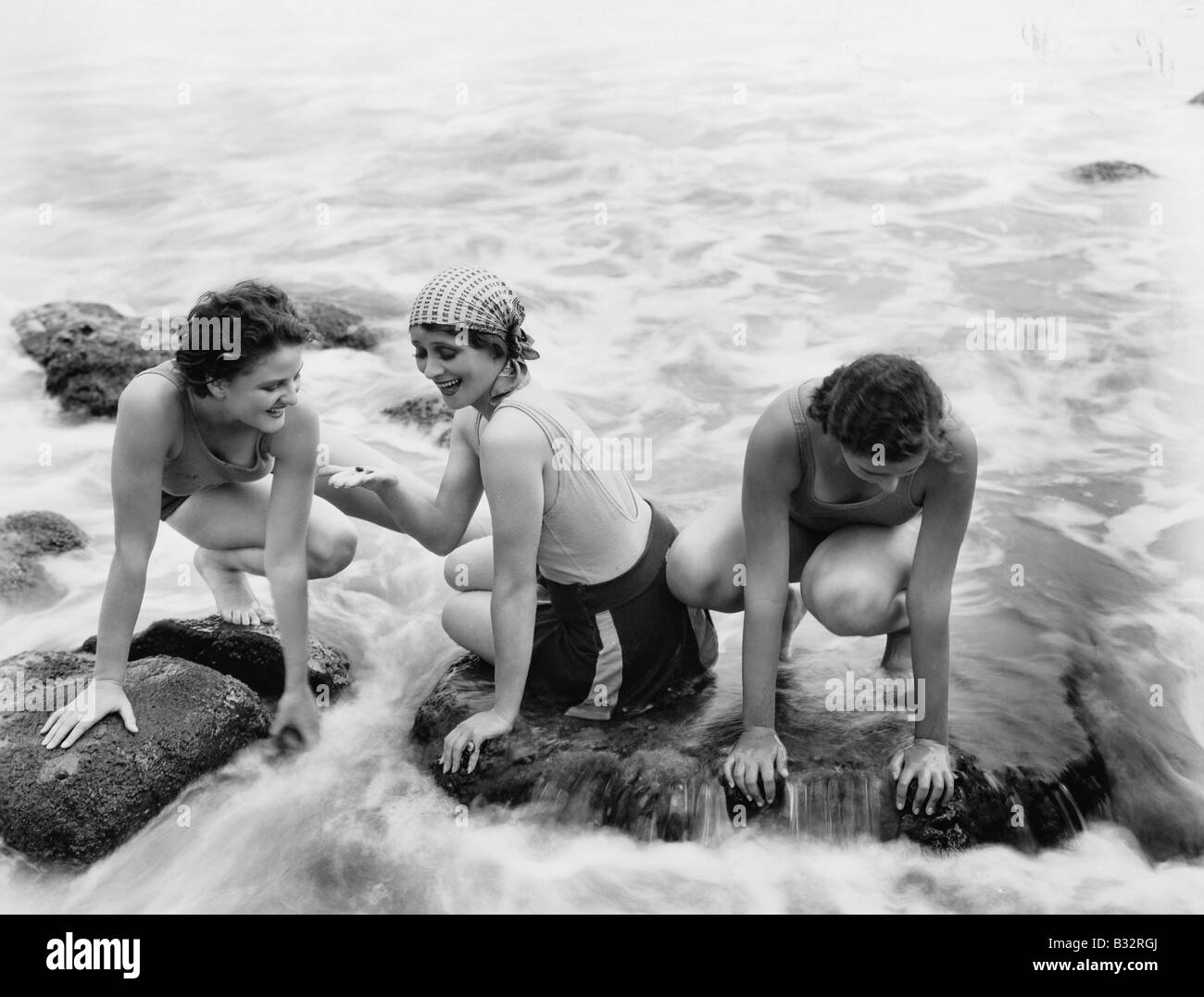 Trois femmes jouant dans l'eau sur la plage Banque D'Images