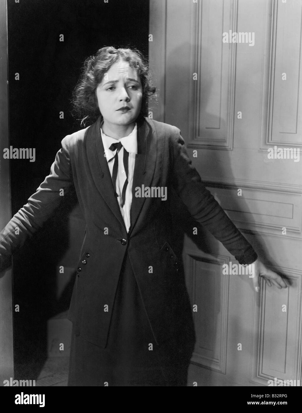 Jeune femme debout à une porte et à la triste Banque D'Images