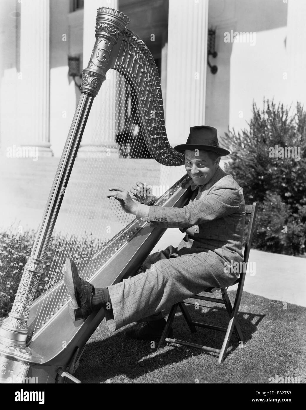 Profil d'un homme jouant de la harpe et souriant Banque D'Images