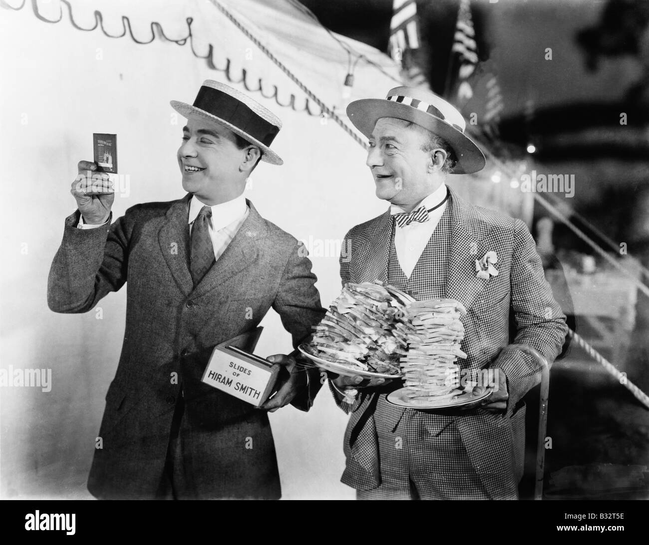 Man holding sandwiches plaques avec l'homme à la diapositive de film à côté de lui Banque D'Images