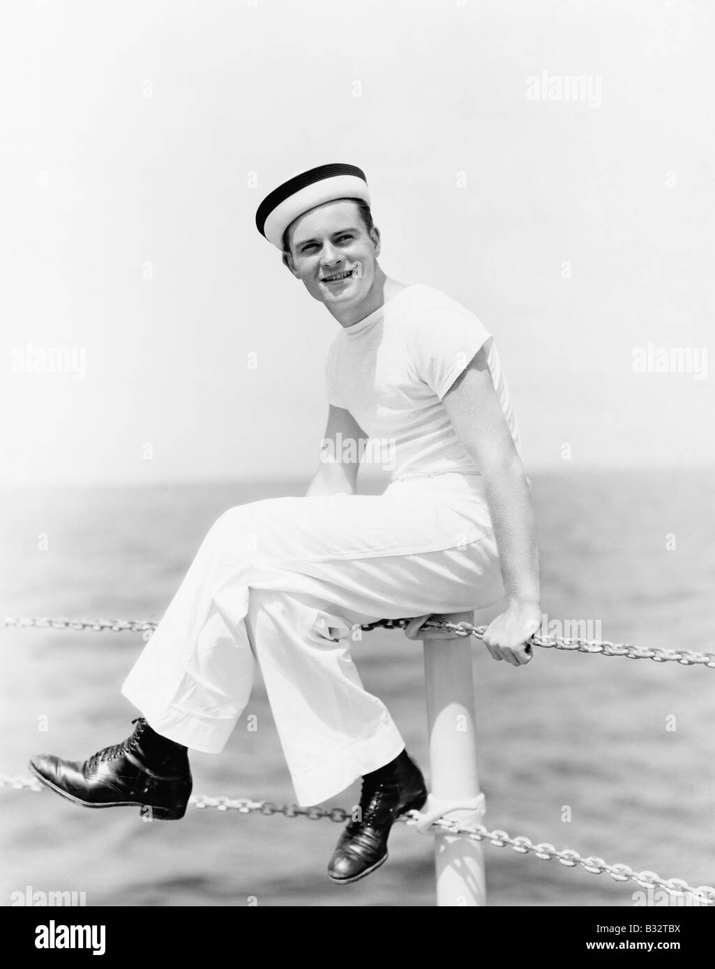Portrait d'un marin assis sur le pôle d'un bateau et smiling Banque D'Images