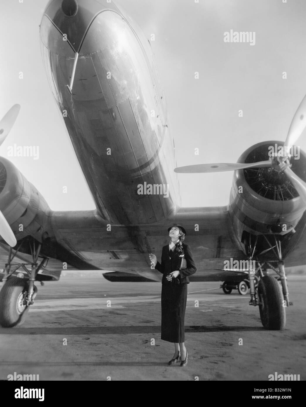 Femme debout sous un gros avion looking up Banque D'Images