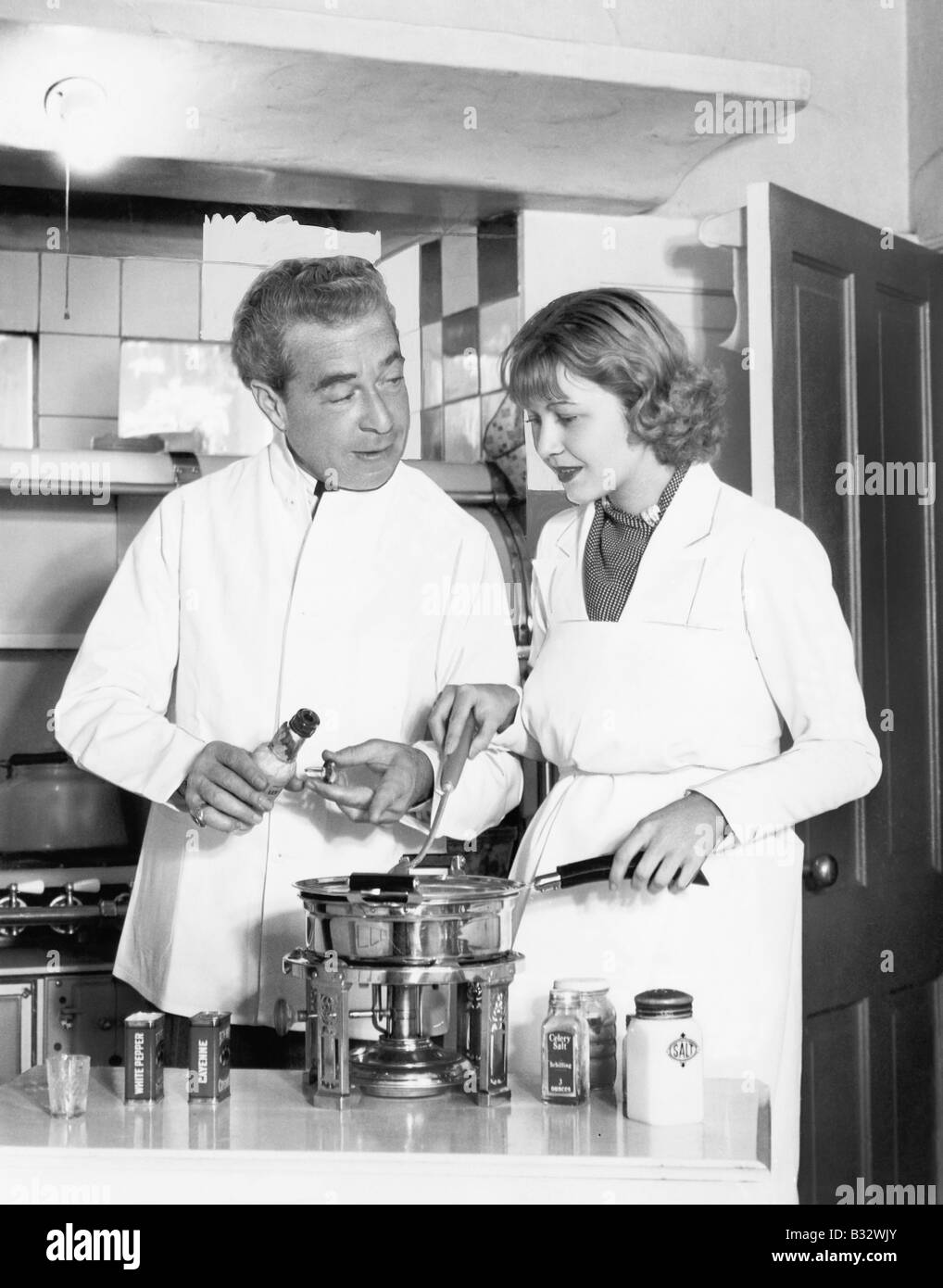 Couple ensemble dans la cuisine préparer une fondue Banque D'Images