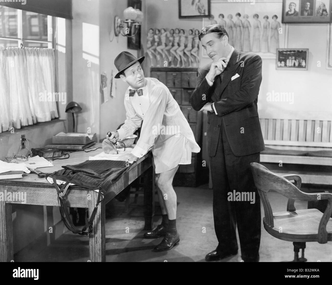 Deux hommes debout dans un bureau, une table à son pantalon Banque D'Images