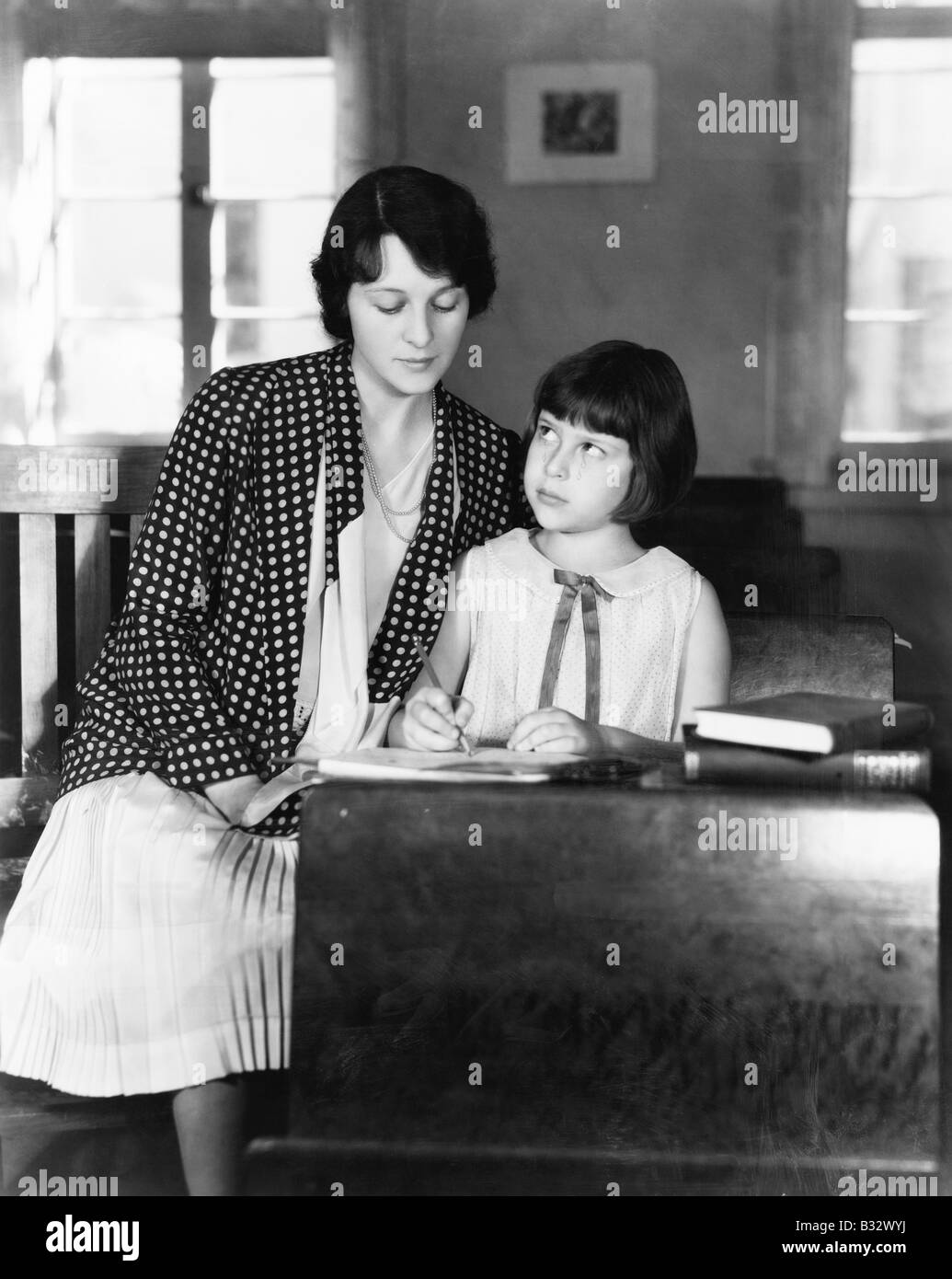 Fille assise avec son professeur dans une salle de classe Banque D'Images