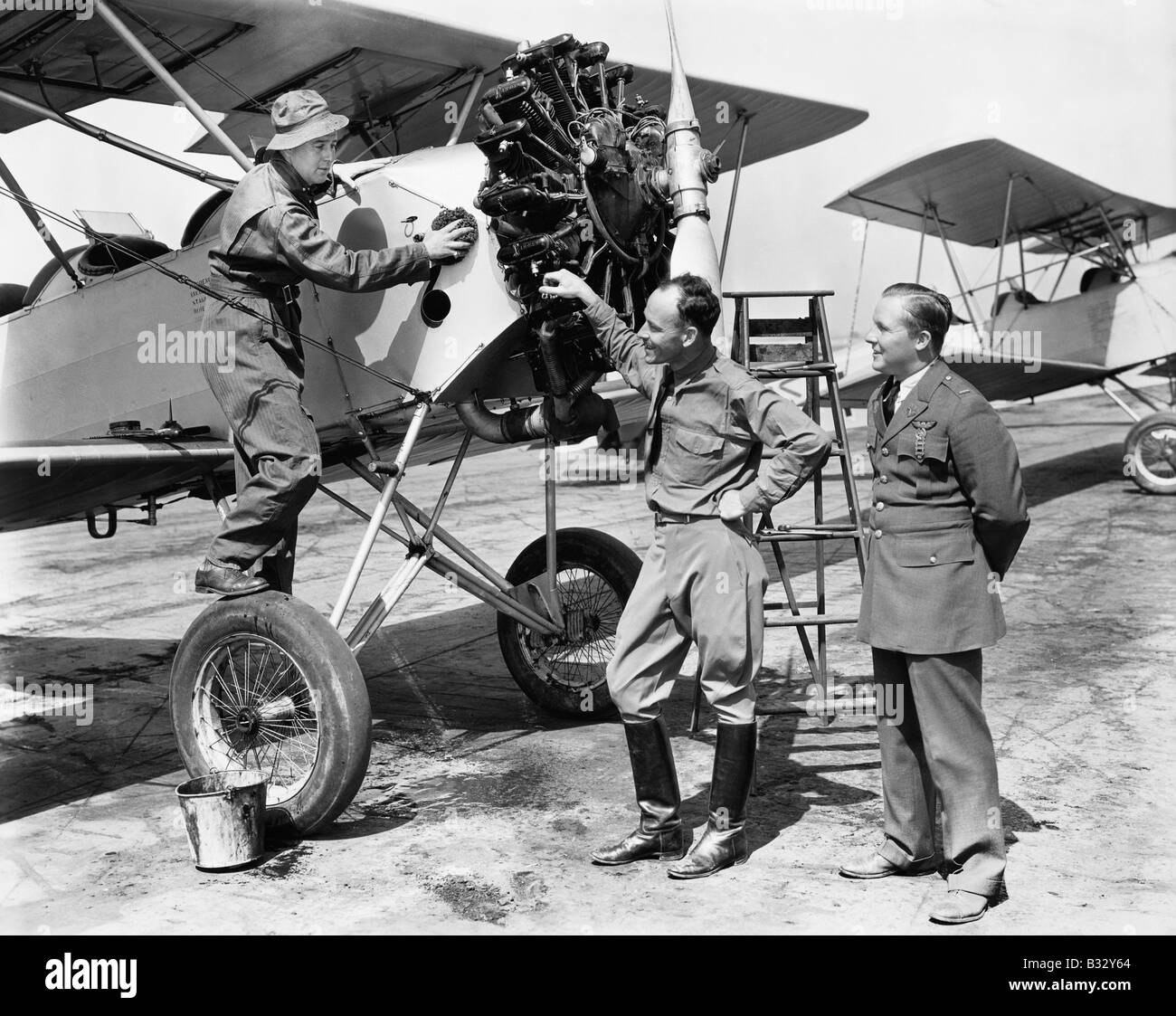 Trois hommes debout à côté d'un aéronef ayant une conversation Banque D'Images